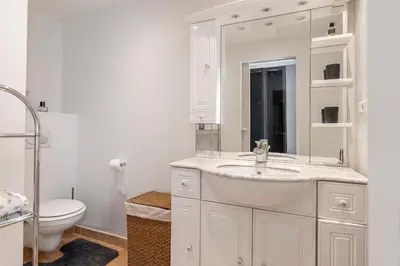 a white bathroom with a sink and a toilet at Appartement 2 chambres proche plage climatisé in Nice