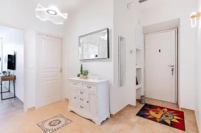 a white room with a white dresser and a mirror at Appartement 2 chambres proche plage climatisé in Nice