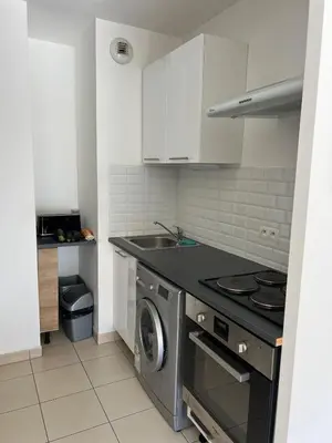 a kitchen with a stove and a washing machine at Nice 2P quiet, tram, convenient in Nice