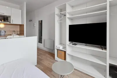 a white bedroom with a large tv and a bed at L'Opéra - Hypercentre - Cosy - No elevator - Minimalist - Sea in Nice