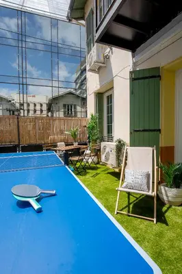 a swimming pool with a table and a chair in a yard at Villa Maska - Studios avec Terrasse proche plage et aéroport de Nice in Nice