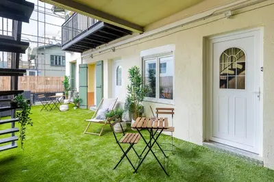 a patio with a lawn with chairs and a door at Villa Maska - Studios avec Terrasse proche plage et aéroport de Nice in Nice
