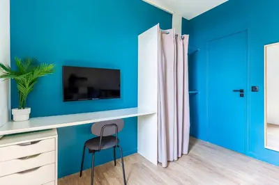 a blue room with a desk and a chair at Villa Maska - Studios avec Terrasse proche plage et aéroport de Nice in Nice
