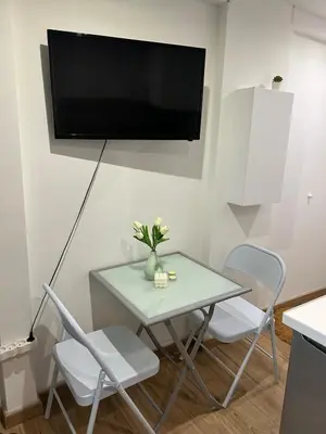 a table with chairs and a tv on a wall at Studio Masséna Nice in Nice
