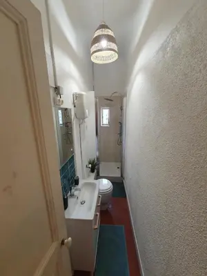 a bathroom with a sink and a toilet and a chandelier at Superbe appartement niçois in Nice