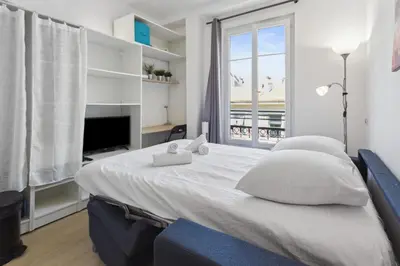 a bedroom with a large white bed and a window at Le Citadin - Hypercentre - Cosy - Shopping - WIFI in Nice