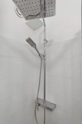 a shower head in a bathroom with white tiles at Le Citadin - Hypercentre - Cosy - Shopping - WIFI in Nice