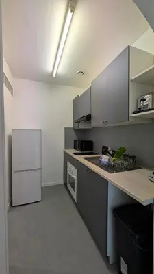 a kitchen with a white refrigerator and a counter at Appartement studio in Nice