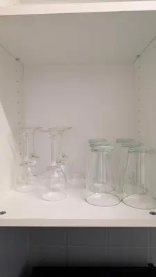 a row of clear glasses sitting on a shelf at Appartement studio in Nice