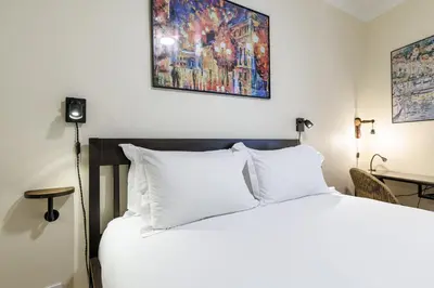 a bed with white pillows and a painting on the wall at Ultra Central 1 Bdr Air-Conditionned in Nice