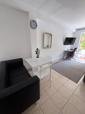 a living room with a black couch and a table at Cœur de Nice - Plage à 5min in Nice