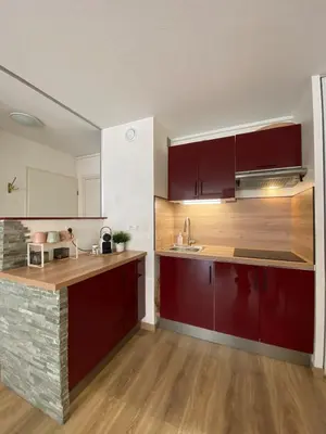 a kitchen with red cabinets and a counter top at Le Spot Niçois in Nice