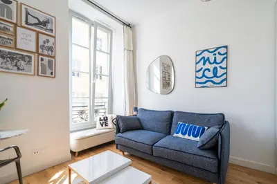 a living room with a blue couch and a window at Studio lumineux Centre-ville in Nice