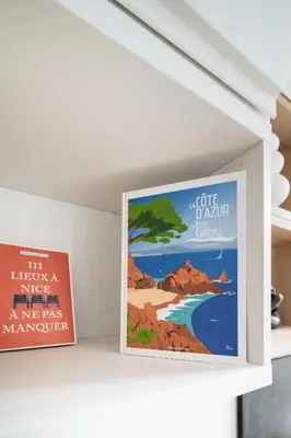a poster of a beach and a sign on a wall at Studio lumineux Centre-ville in Nice