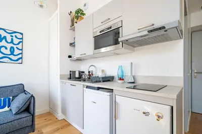 a kitchen with white cabinets and a sink at Studio lumineux Centre-ville in Nice
