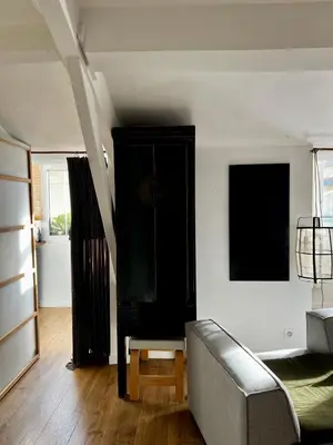 a living room with a couch and a black cabinet at Grand studio Zen à côté de la promenade des Anglais in Nice