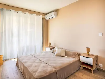 a bedroom with a large bed and a window at Apartment Cros de Cagnes-2 by Interhome in Cagnes-sur-Mer