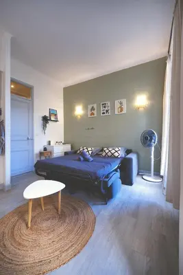 a bedroom with a bed and a table and a rug at Nouveau charmant Studio à 5 Minutes de la mer in Nice