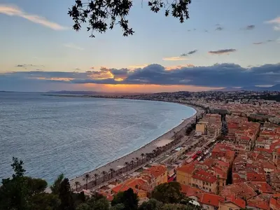 a view of a city and the beach at sunset at Nouveau charmant Studio à 5 Minutes de la mer in Nice