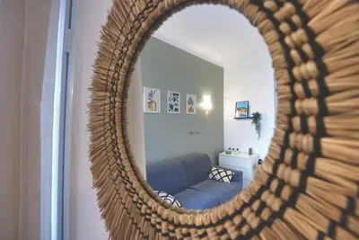 a living room with a blue couch and a mirror at Nouveau charmant Studio à 5 Minutes de la mer in Nice