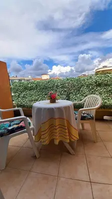 a table and chairs on a patio with a view of a field at Nice flat near sea and center in Nice