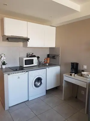 a kitchen with a washing machine and a microwave at Nice flat near sea and center in Nice