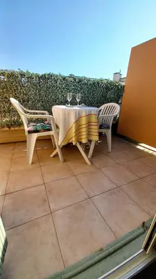 a table and chairs with wine glasses on a patio at Nice flat near sea and center in Nice