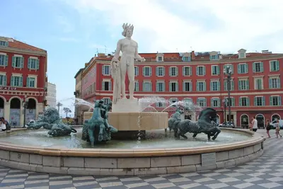 a statue of a man in a fountain in front of a building at Les Suites Massena in Nice