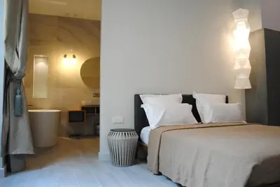 a bedroom with a bed with white pillows at Les Suites Massena in Nice