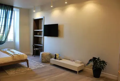 a bedroom with a bed and a table in a room at Les Suites Massena in Nice