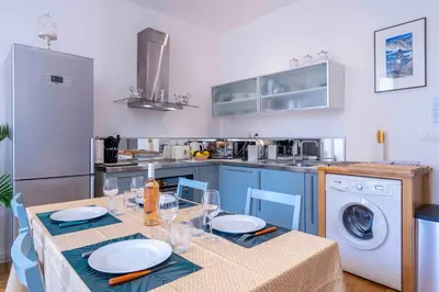 a kitchen with a table and a washing machine at Beautiful Provencal apartment, fully equipped, beach 300m away - FONTAINE 3 in Nice