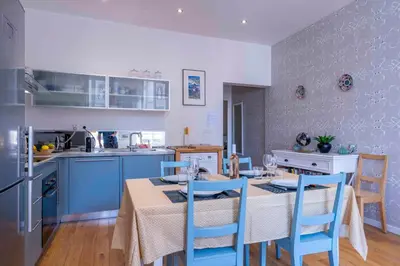 a kitchen with a table and blue chairs in a kitchen at Beautiful Provencal apartment, fully equipped, beach 300m away - FONTAINE 3 in Nice