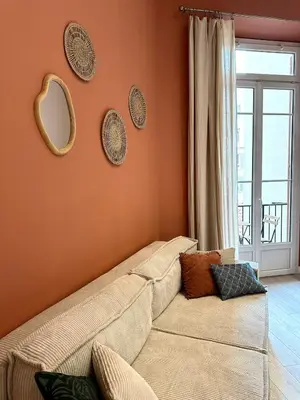 a living room with a couch and mirrors on the wall at Harmonie Nature au cœur de Nice in Nice