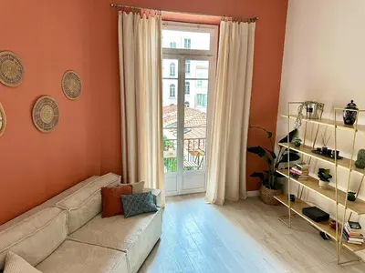 a living room with a couch and a large window at Harmonie Nature au cœur de Nice in Nice