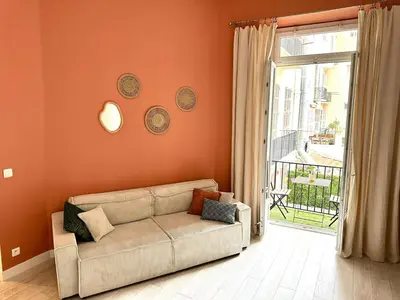 a living room with a couch in front of a window at Harmonie Nature au cœur de Nice in Nice