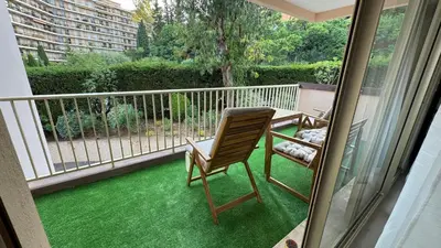 a patio with a chair and a table on a balcony at Azur Stay in Nice