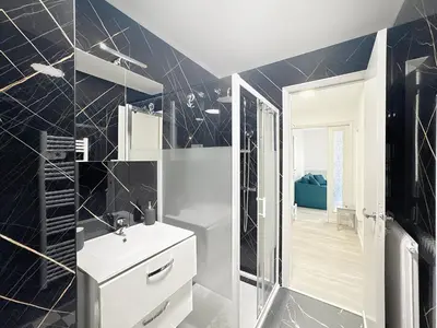 a black and white bathroom with a sink and a mirror at Azur Stay in Nice