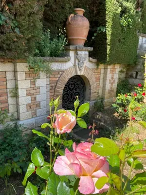a garden with a brick arch with a vase on it at STUDIO BALCON CALME AVEC PARKING 5mn de la MER in Nice