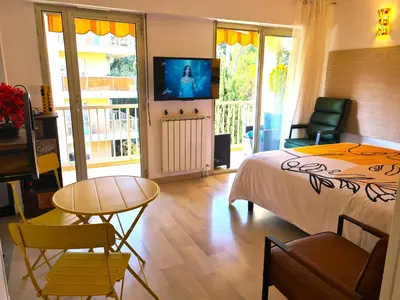 a bedroom with a bed and a table and a television at STUDIO BALCON CALME AVEC PARKING 5mn de la MER in Nice