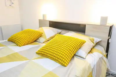 a bed with two yellow pillows on it at Cozy studio in Nice Désambrois in Nice