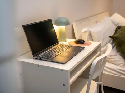 a laptop computer sitting on a desk next to a bed at Duplex Saveria - Terrace - Netflix - Beach in Nice