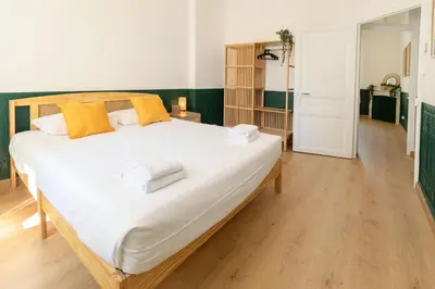 a bedroom with a large white bed with yellow pillows at Maison Bianchi - Downtown Nice Pertinax in Nice