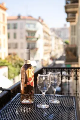 a bottle and two wine glasses sitting on a table at Maison Bianchi - Downtown Nice Pertinax in Nice