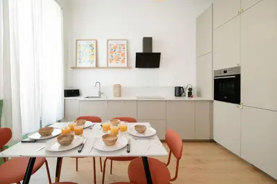 a white kitchen with a table with plates of food on it at Maison Bianchi - Downtown Nice Pertinax in Nice