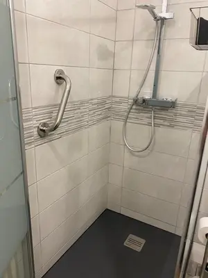 a shower with a hose in a tiled bathroom at Spacious 2 BR 1 block from beaches - and the TRAM in Nice