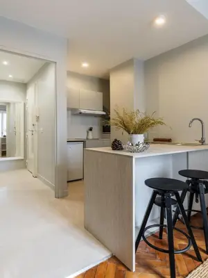a kitchen with a counter and two stools at Appartement moderne proche mer et transports in Nice