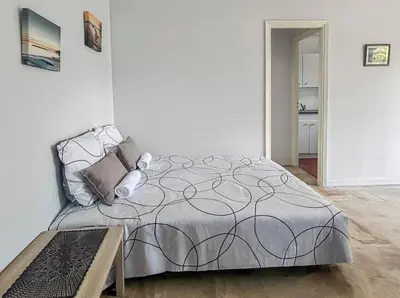 a white bedroom with a bed and a table at Studio proche de la mer avec parking Cagnes-sur-Mer in Cagnes-sur-Mer