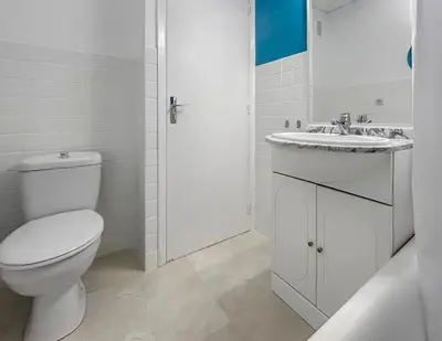 a white bathroom with a toilet and a sink at Studio proche de la mer avec parking Cagnes-sur-Mer in Cagnes-sur-Mer