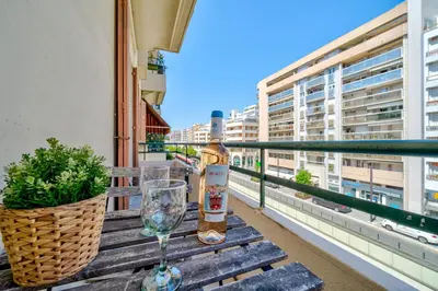a bottle of wine and a glass on a table on a balcony at Studio moderne proche mer - Balcon et Climatisé in Nice