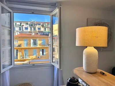 a lamp sitting on a table next to a window at La vie est belle - T2 - Coeur de Nice in Nice